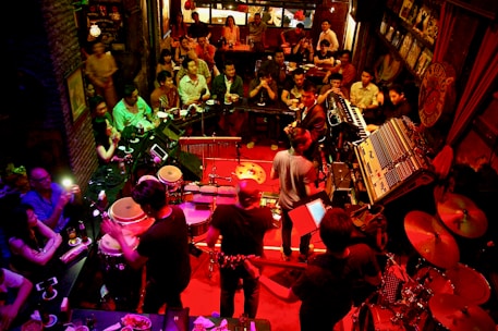 Live music performance on stage with an engaged audience at a bar.