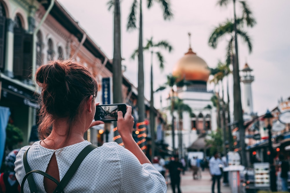 selective focus photography of woman taking photo