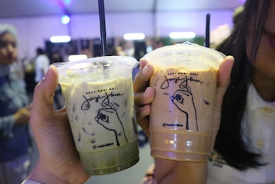 Close-up of hands holding coffee cups during a language exchange event.