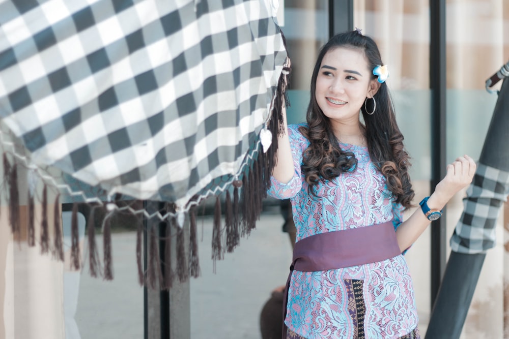 smiling woman holding hanging textile at daytime