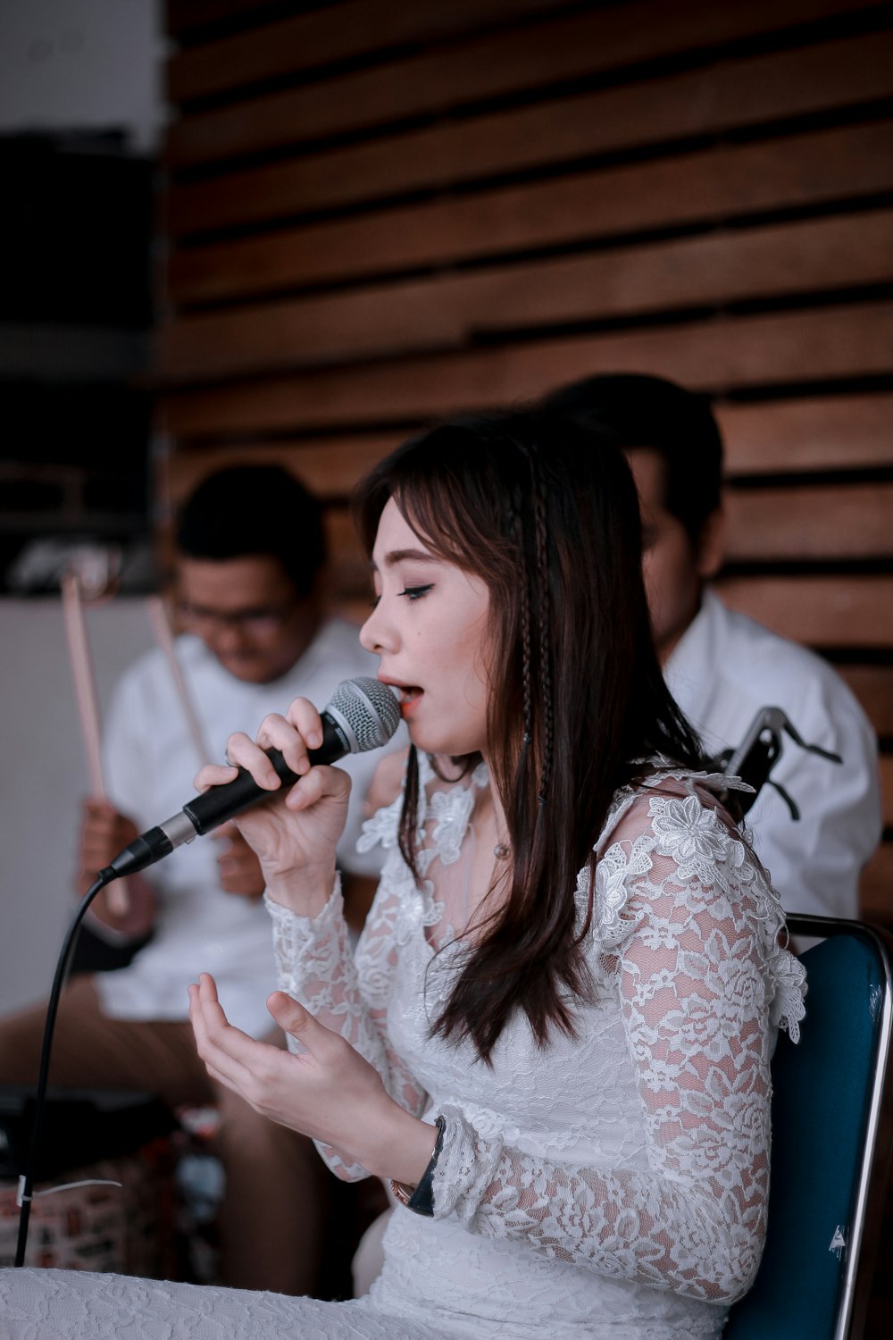 woman using microphone while sitting