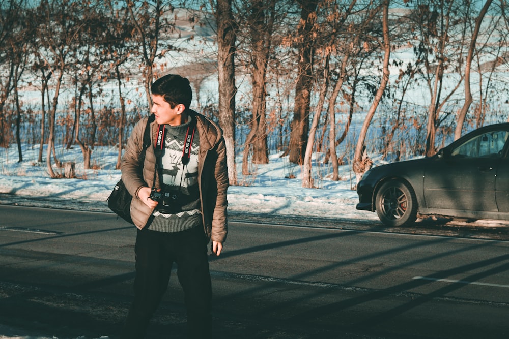 man wearing brown jacket standing near vehicle