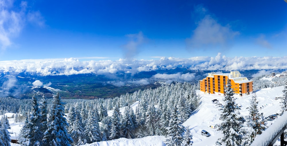 yellow building on snow covered mountain during daytime
