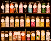 Rows of candy jars neatly arranged on shelves in a cozy store setting.