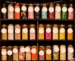 Rows of candy jars neatly arranged on shelves in a cozy store setting.