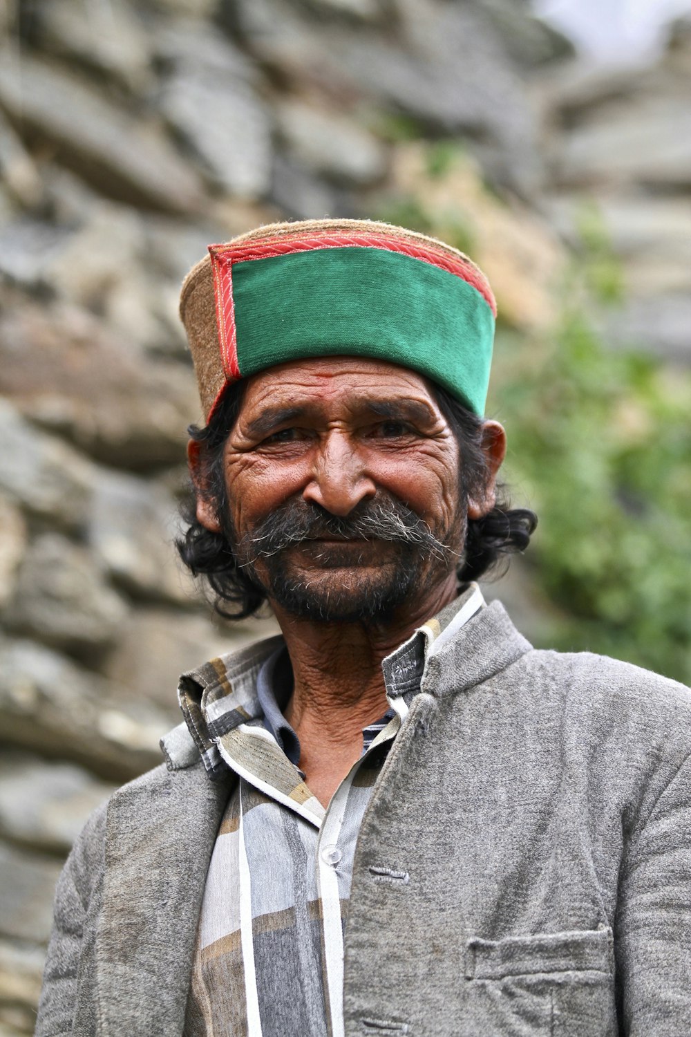 man wearing green hat and gray collared shirt]