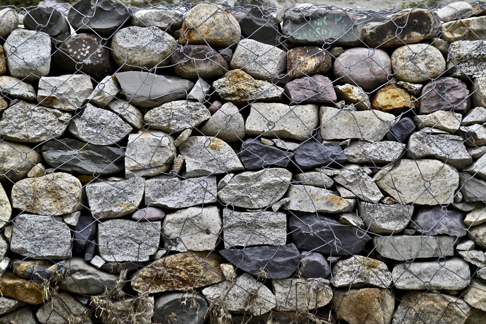 pile of rock fence with iron wire fence