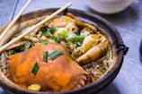 Steaming hot clay pot filled with fragrant jasmine rice, vegetables, and marinated chicken.