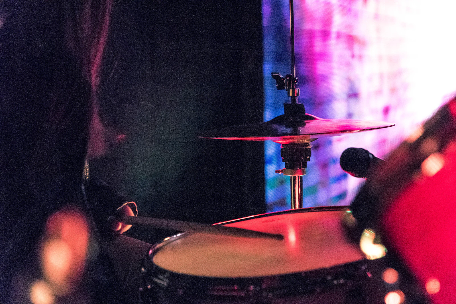 Person sitting at a drum kit, viewed from behind — the first moments before playing