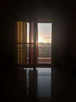 Wide shot of a bright living room with a large velcro mosquito net covering the balcony door.