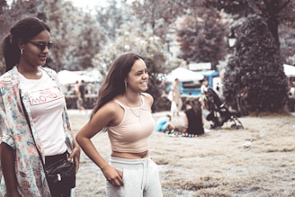 Women walking in stylish blue rubber sneakers on a sunny park path.