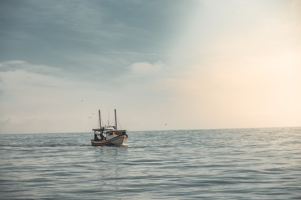 white boat sailing on ocean