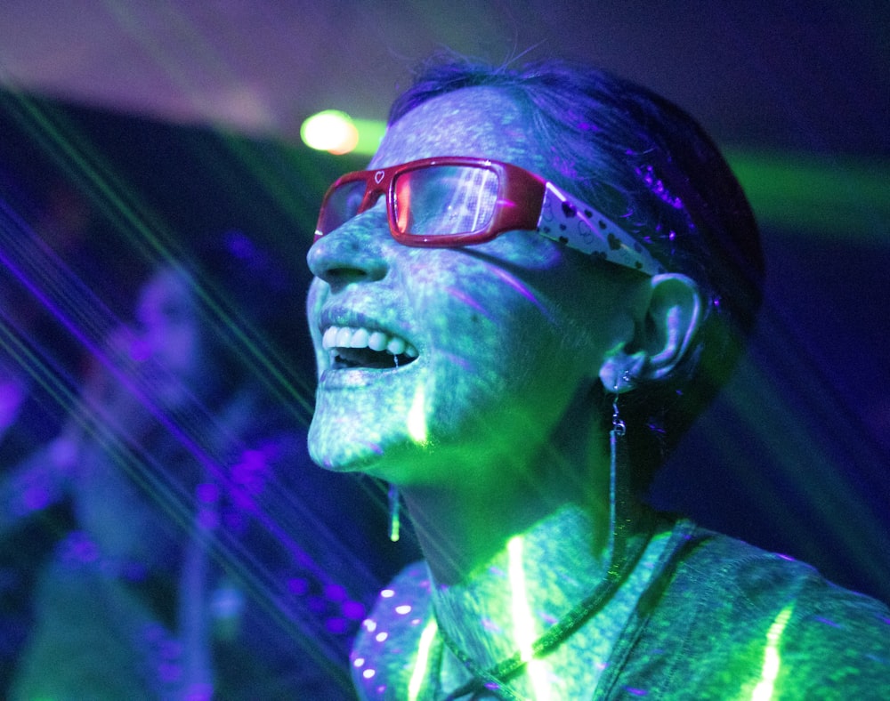 Femme portant des lunettes à monture rouge tout en souriant