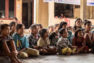 group of childrens sitting on ground