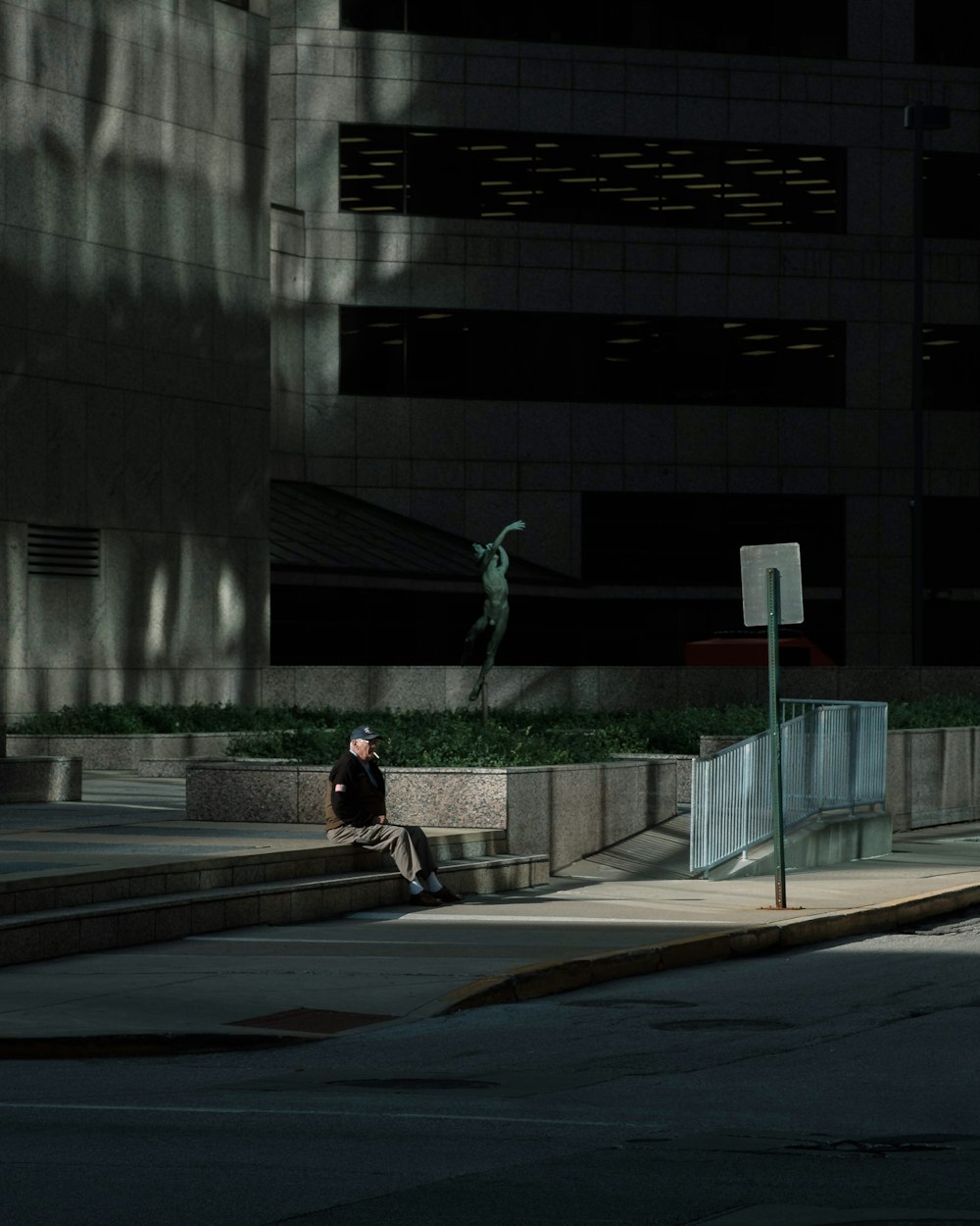 man sitting on stairs outside building