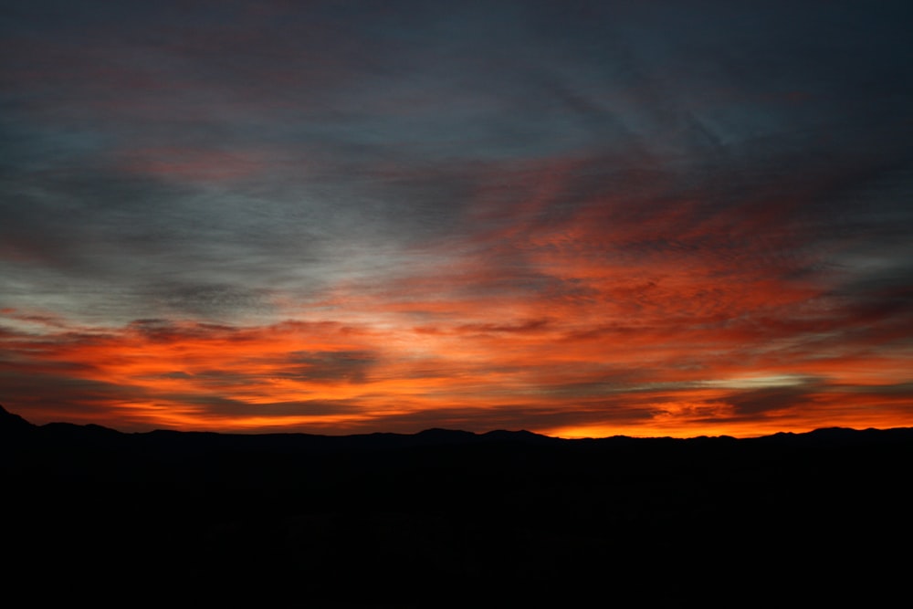 silhouette photography of mountain under clouds