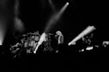 grayscale photo of man singing on stage