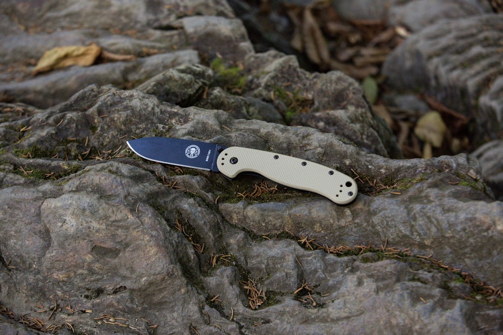 a knife laying on top of a rock