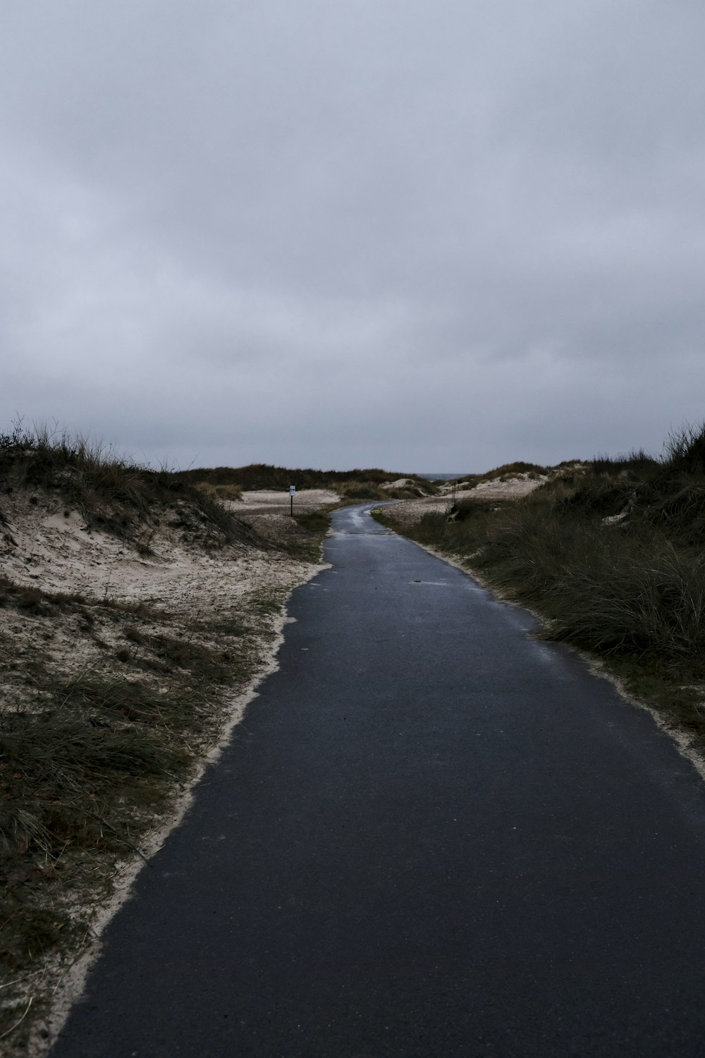 empty paved road under white sky