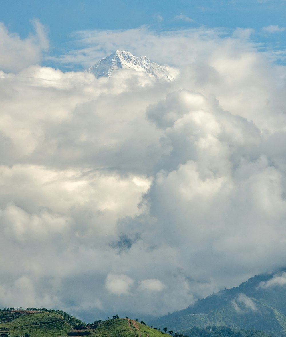 cone mountain covered with snow and clouds