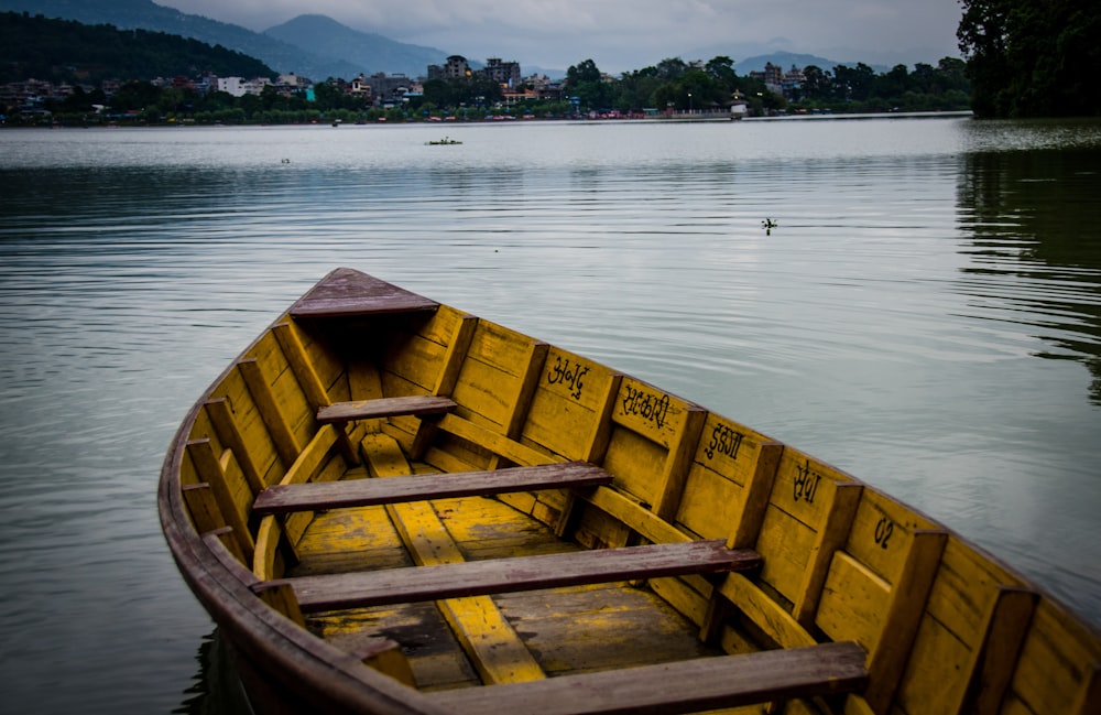 yellow and brown wooden boat on lake during golden hour