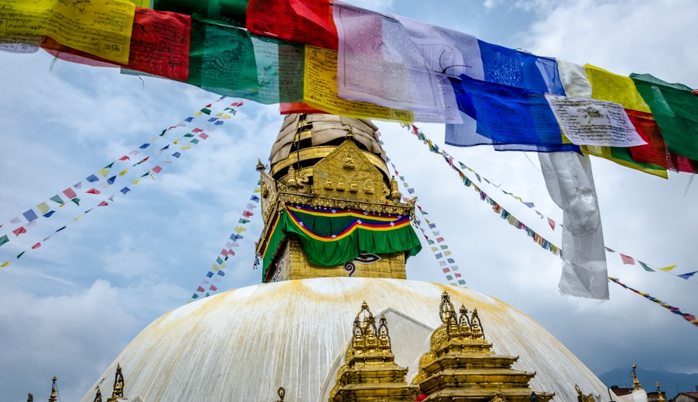 a large white dome with colorful flags hanging from it