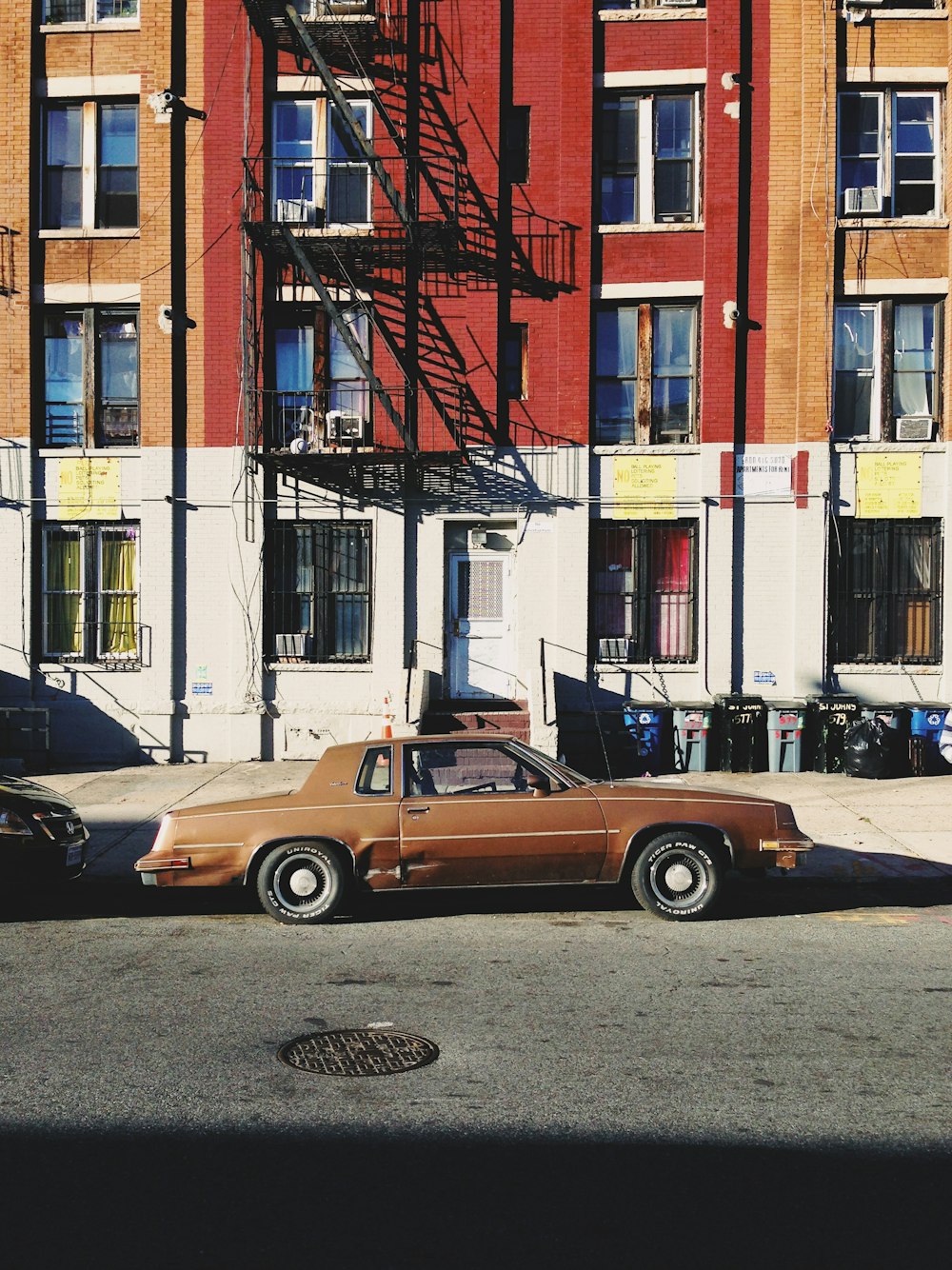 brown coupe parked beside road