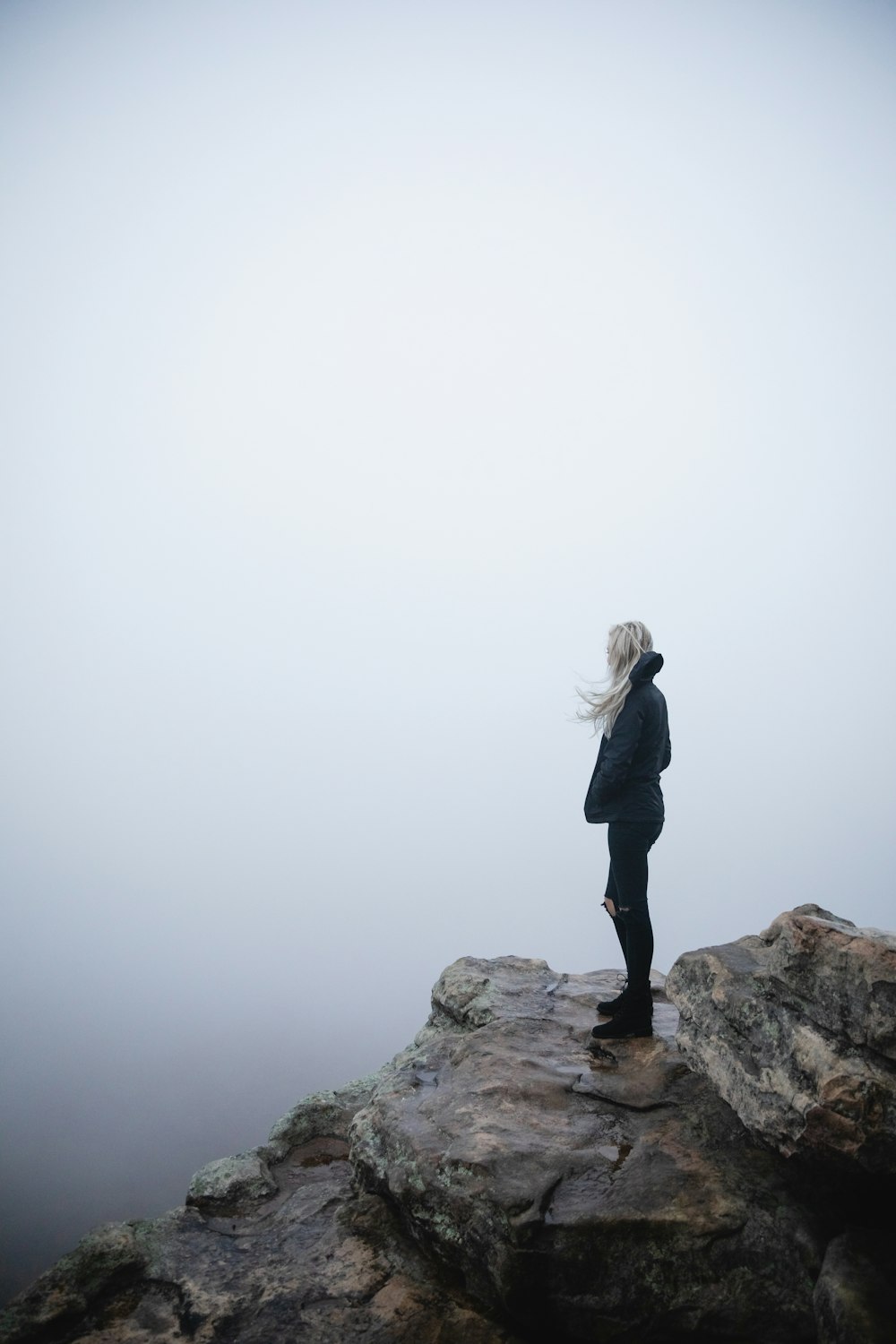 Frau steht auf Klippe