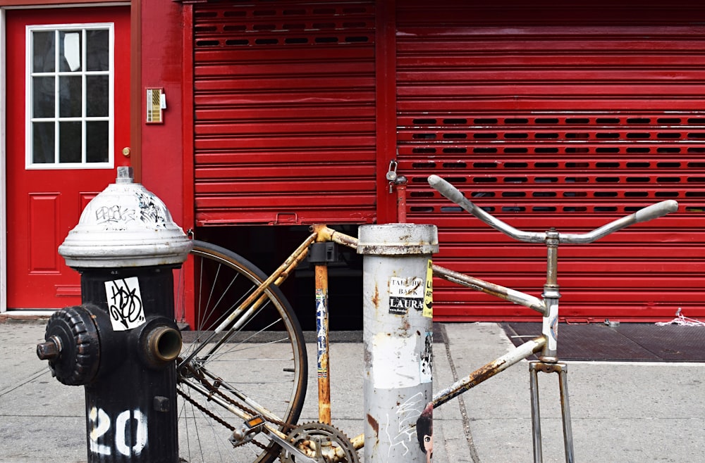 red bicycle parked beside gray metal tank