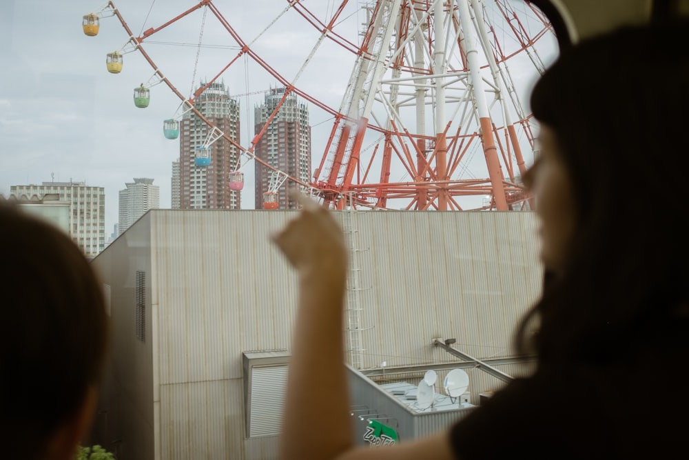selective focus photography of man in front of ferris wheel