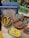 A selection of decorative items including Christmas-themed ornaments resembling butter sticks, cookies, and crackers are displayed. A series of cookbooks titled 'Betty Crocker Lost Recipes' are stacked in the background. An assortment of kitchenware, including salt and pepper shakers, is also visible.