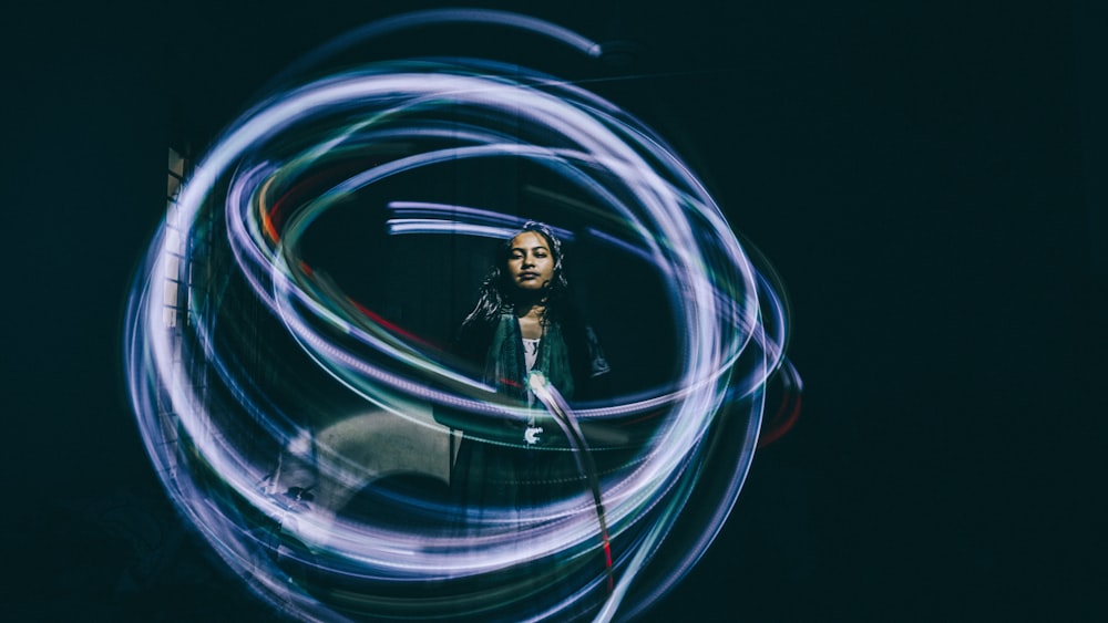 blue lights streaking around standing woman