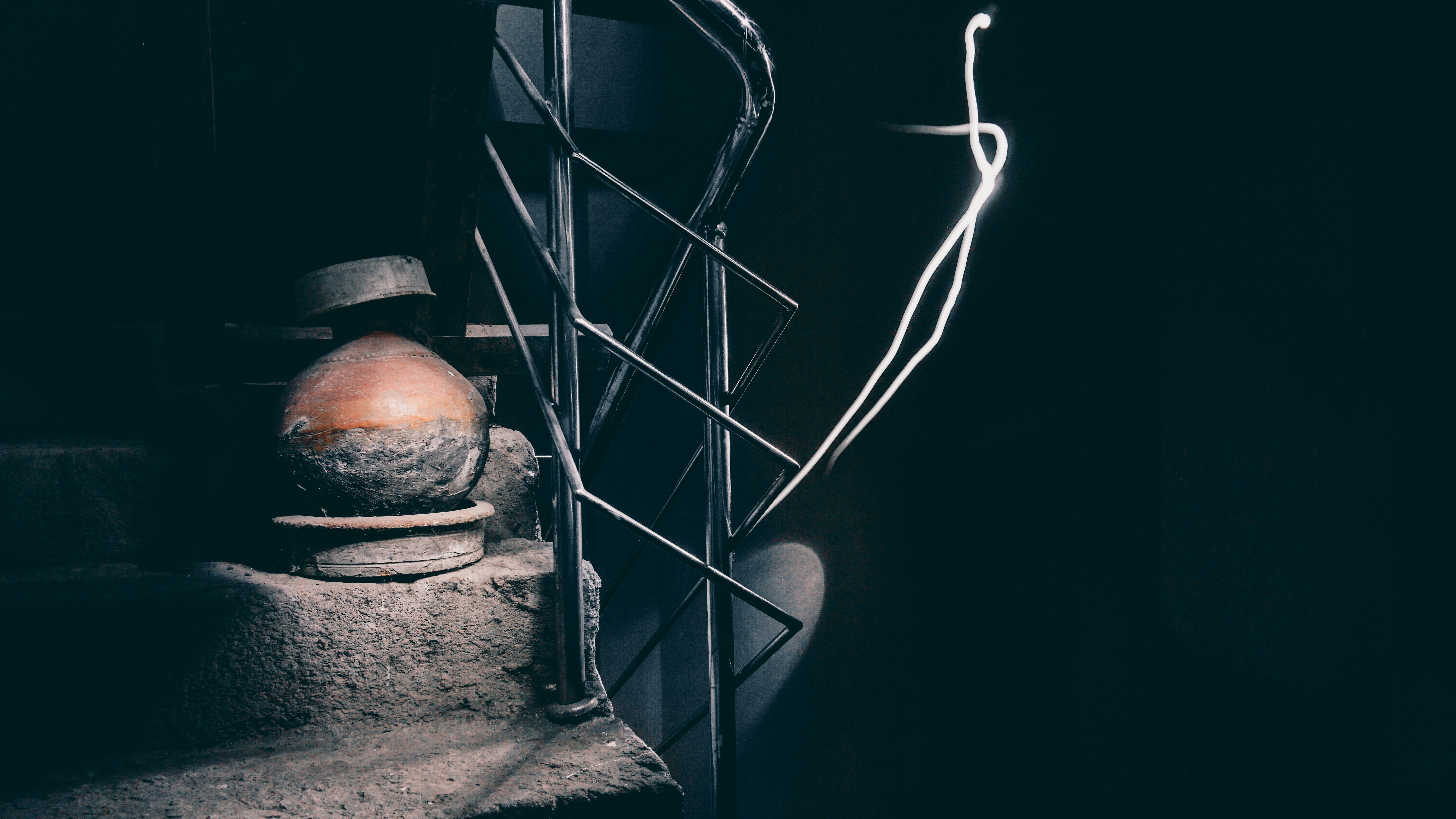 ein dunkler Raum mit einer Lampe und einer Vase