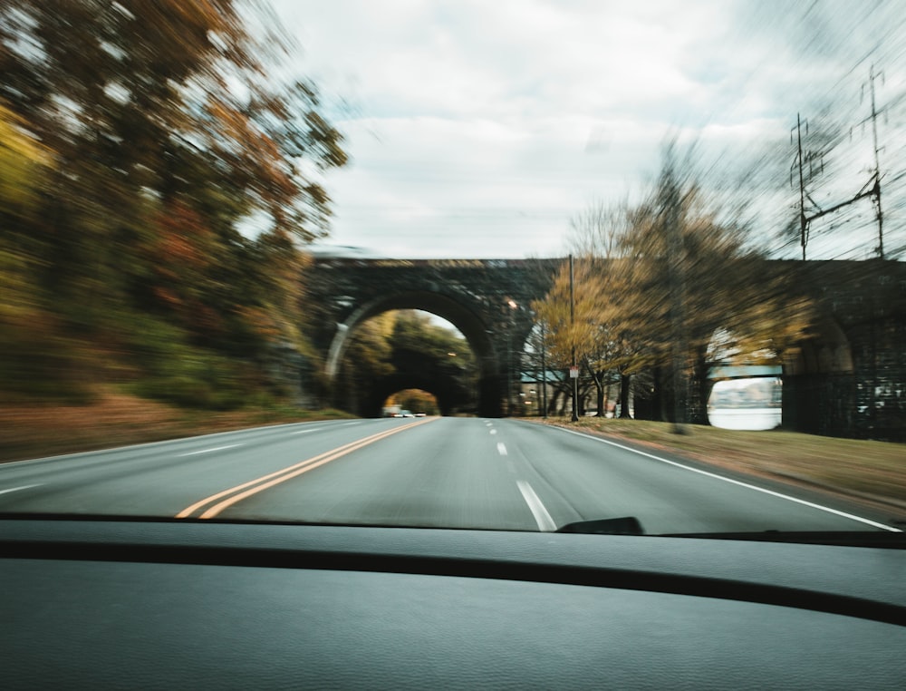 a car driving down a road next to a bridge