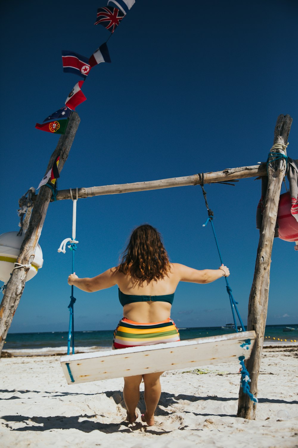 woman riding swing on shore