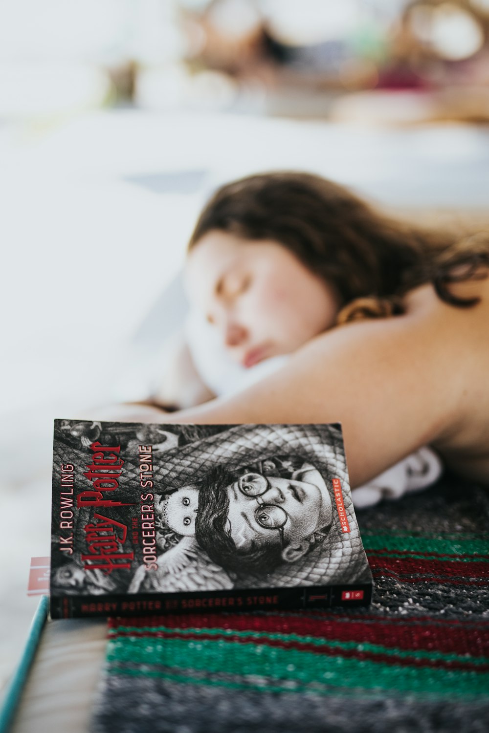 femme allongée en position couchée à côté d’un livre Harry Potter fermé