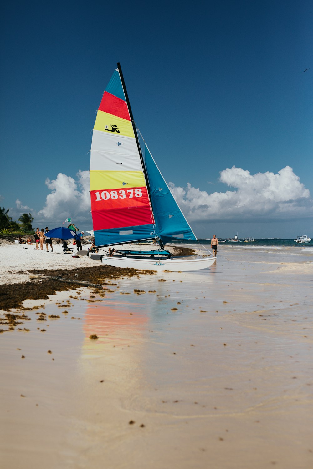 white sailboat on shore at daytime