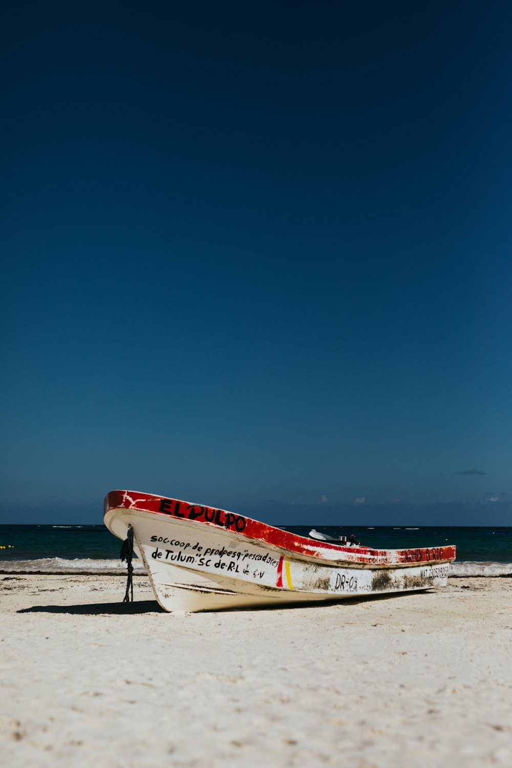 bateau blanc et rouge près de l’océan