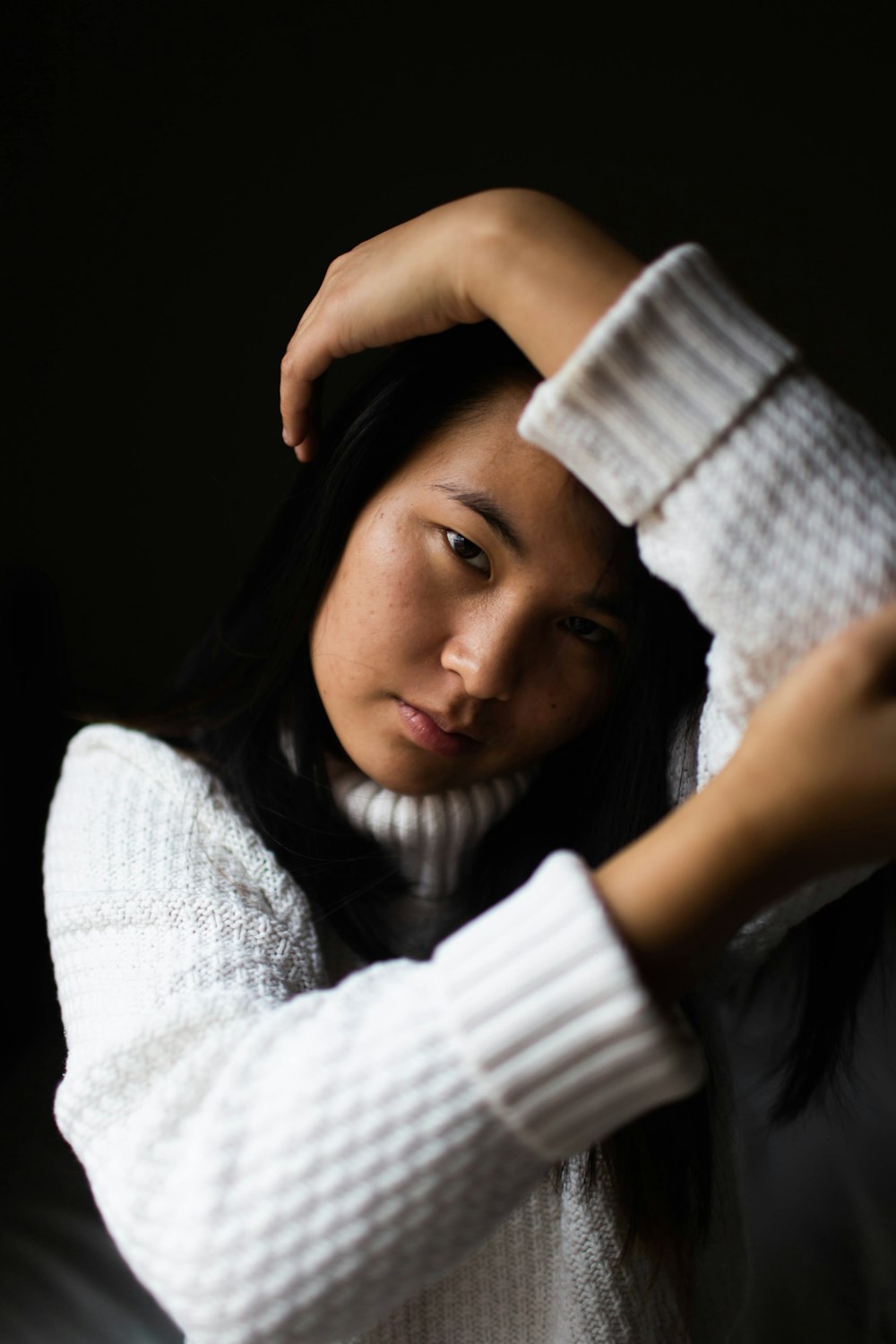 woman resting her left arm on her head