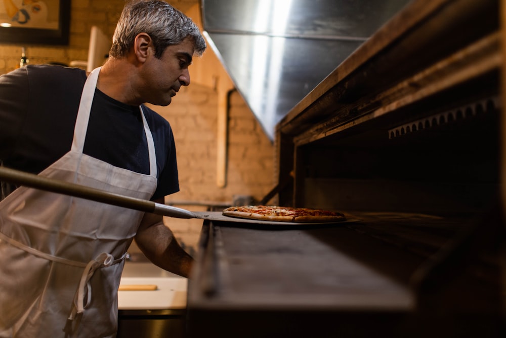 man baking pizza