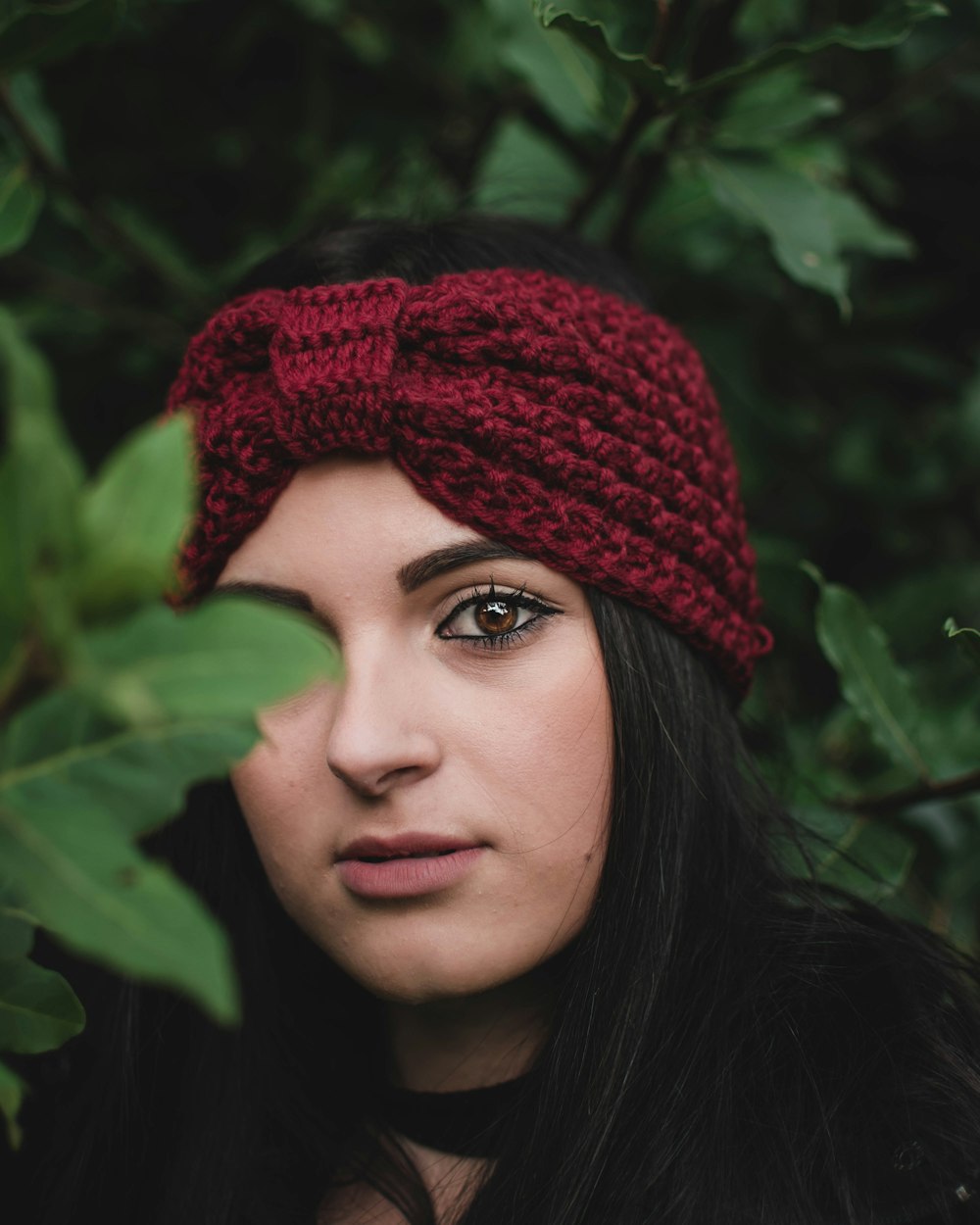 woman standing behind green leafed tre