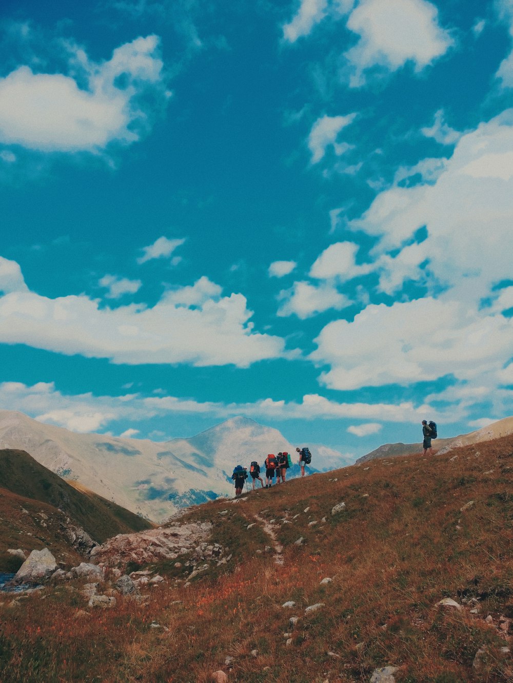 group of people standing on mountain range