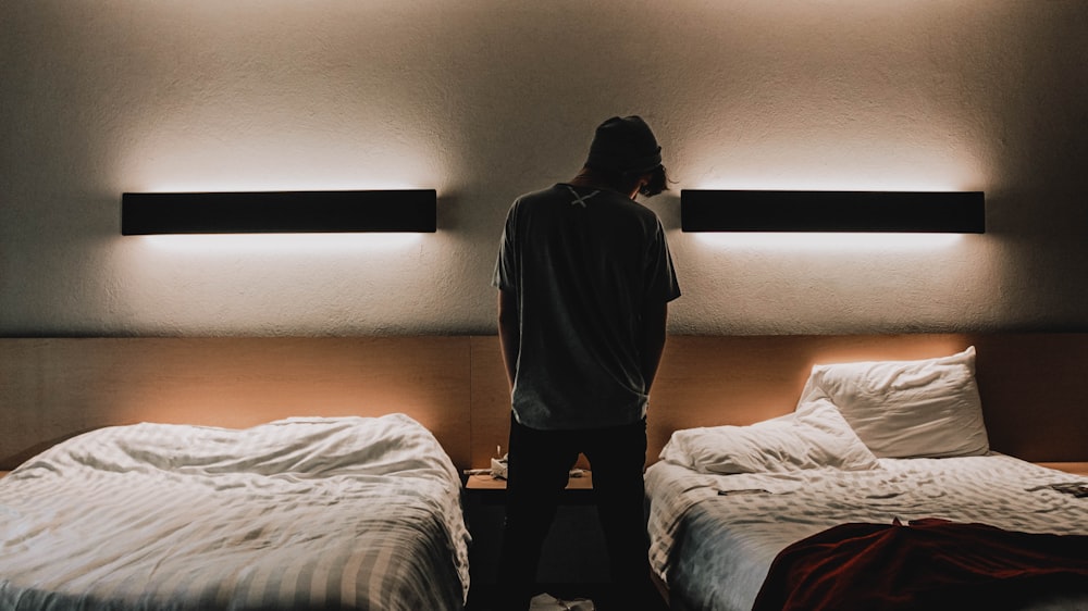 silhouette d’une personne debout entre deux lits