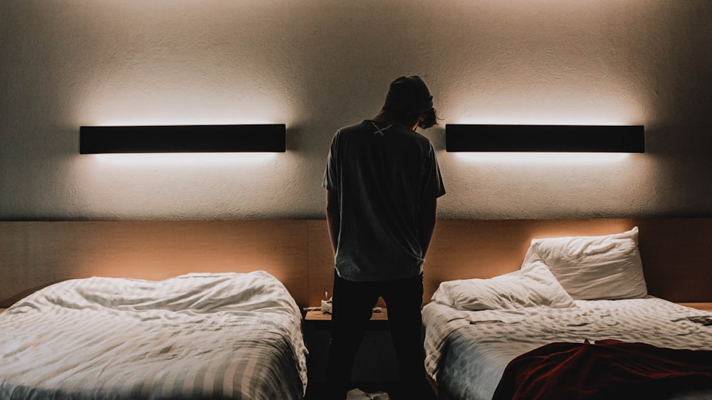 silhouette of person standing between two beds