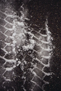 Close-up of tire tracks left on a black asphalt road freshly laid by rhstroi.