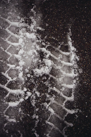Close-up of tire tracks left on a black asphalt road freshly laid by rhstroi.