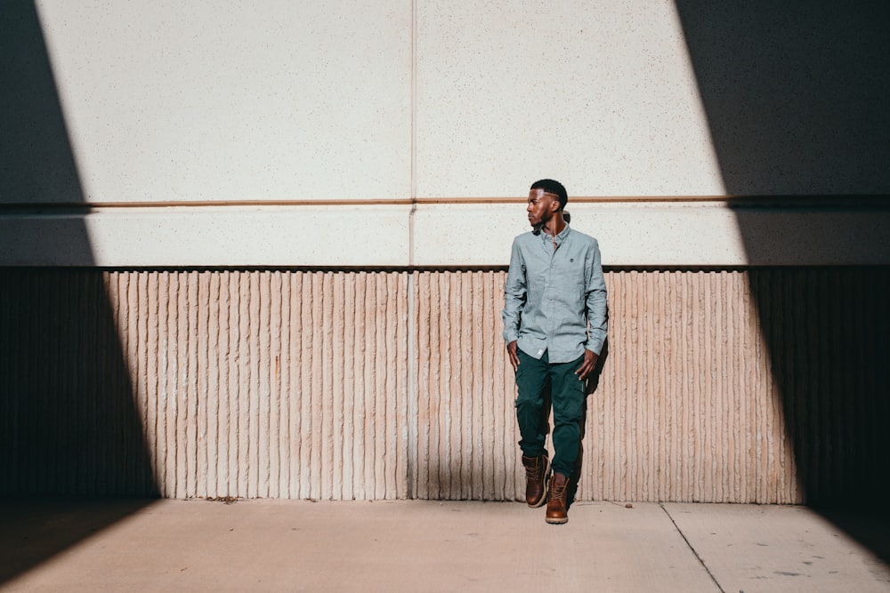 man leaning on white wall