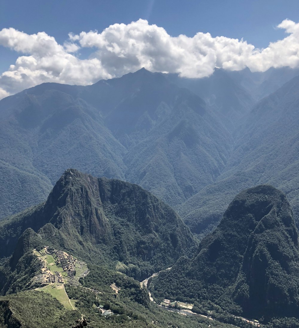 昼間の曇り空の下の緑の岩山