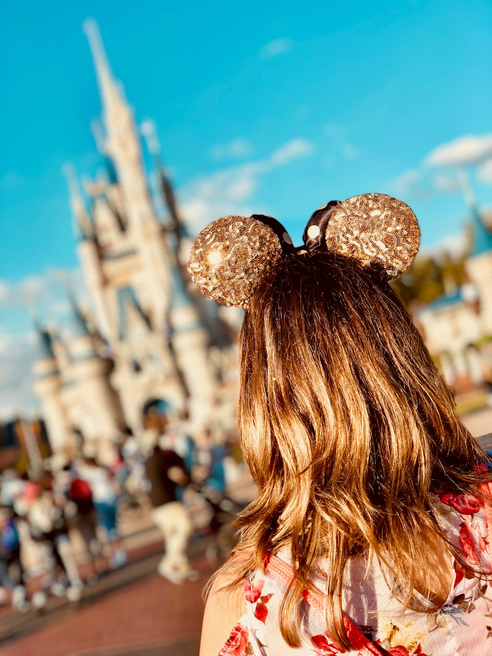 mujer con orejas doradas de Mickey en Disneyland