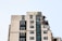 A partially demolished high-rise building with visible rubble on the right side, and graffiti such as 'VOID' and 'CARF' on the windows. The structure appears worn and neglected, suggesting abandonment or urban decay.